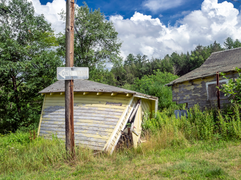 a dilapidated shed leaning over behing a telephone pole with a one way sign on it in Hiawatha, KS and Surrounding Areas